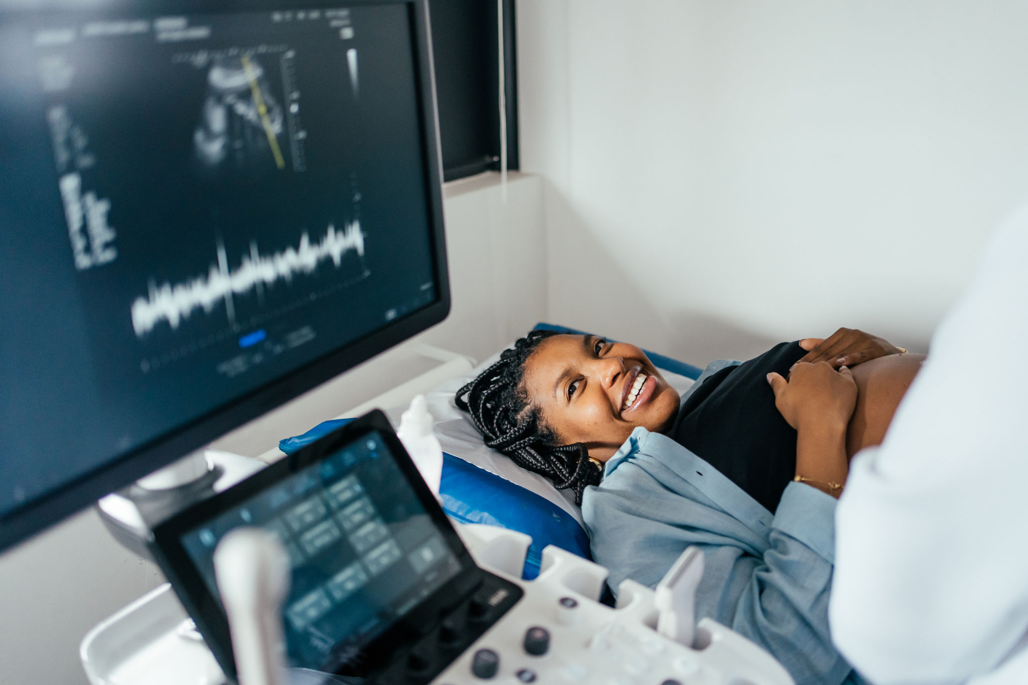 Smiling woman during medical ultrasound examination with healthcare professional